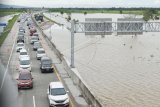 Susasana jalan tol Trans Jawa ruas Ngawi-Kertosono pada KM 603-604 yang terendam banjir di Desa Glonggong, Balerejo, Kabupaten Madiun, Jawa Timur, Kamis (7/3/2019). Luapan Sungai Madiun serta beberapa anak sungainya mengakibatkan sejumlah wilayah di Kabupaten Madiun terendam banjir, dan jalan tol yang terendam tersebut hanya difungsikan satu ruas dengan sistem buka tutup. (ANTARA FOTO)