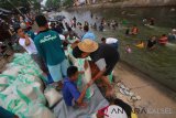 Sejumlah relawan haul KH Muhammad Zaini Abdul Ghani (Abah Guru Sekumpul) bergotong royong membersihkan beras di Irigasi Martapura, Kalimantan Selatan, Sabtu (9/3/2019).Puluhan ton beras disiapkan untuk jamaah yang menghadiri Haul Abah Guru Sekumpul ke-14.Foto Antaranews Kalsel/Bayu Pratama S.