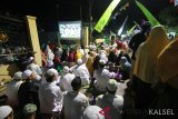 Jamaah melihat pelaksanaan Haul KH Muhammad Zaini Abdul Ghani (Abah Guru Sekumpul) ke-14 melalui layar lebar yang di sediakan Panitia di Sekumpul,Martapura, Kalimantan Selatan, Minggu (10/3/2019). Puluhan ribu jamaah Haul Abah Guru Sekumpul ke-14  dari berbagai daerah baik luar Negeri maupun dalam Negeri memadati kawasan Makam Abah Guru Sekumpul untuk mengikuti rangkaian kegiatan haul. Foto Antaranews Kalsel/Bayu Pratama S.