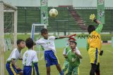 Pemain dari tim SDN Kayuringin (putih) menghalau bola saat menjalani babak semifinal Milo Football Championship melawan tim SD Madrasah Ibtidaiyah Negeri 2 Margasari (hijau) di Stadion Siliwangi, Bandung, Jawa Barat, Minggu (10/3/2019). Milo Football Championship yang merupakan kompetisi U-11 antar-Sekolah Dasar dan diikuti oleh 640 tim yang dibagi dari lima regional tersebut digelar untuk pencarian bakat  muda pesepakbola sejak dini. ANTARA JABAR/Raisan Al Farisi/agr.