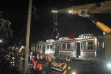 Sejumlah petugas PT KAI melakukan evakuasi pengangkatan badan gerbong KRL Commuter Line 1722 yang anjlok di pintu perlintasan Kebon Pedes, Tanah Sareal, Kota Bogor, Jawa Barat, Minggu (10/3/2019) malam. Petugas dibantu alat berat masih melakukan evakuasi pengangkatan gerbong KRL Commuter Line 1722 (Jatinegara-Bogor) yang anjlok dan proses perbaikan diupayakan selesai pada Minggu (10/3/2019) malam serta ditargetkan perjalanan KRL dapat kembali normal pada Senin (11/3/2019). ANTARA JABAR/Arif Firmansyah/agr