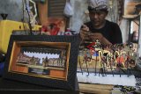 Perajin menyelesaikan pembuatan kerajinan miniatur wayang kulit di Indramayu, Jawa Barat, Senin (11/3/2019). Kerajinan miniatur wayang kulit tersebut dijual seharga Rp500 ribu hingga Rp2 juta perunit tergantung motif. ANTARA JABAR/Dedhez Anggara/agr