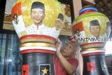 Seniman Bambang Sriyanto (69 tahun) menyelesaikan pembuatan lukisan limbah cangkang telur Pemilihan Presiden 2019 melalui media guci di rumahnya Perumnas Bantarjati, Kota Bogor, Jawa Barat, Selasa (12/3/2019). Lukisan limbah cangkang telur yang bergambar pasangan calon Presiden dan Wakil Presiden 2019 yang dibuat selama dua bulan tersebut untuk memeriahkan perhelatan Pemilihan Presiden 2019. ANTARA JABAR/Arif Firmansyah/agr.