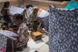 Pembatik menyelesaikan proses pembuatan batik kombinasi tulis dan cap motif dua jari di Batik Putra Laweyan, Solo, Jawa Tengah, Selasa (12/3/2019). Batik motif dua jari tersebut banyak dipesan relawan dan pendukung pasangan Capres no urut 02 Prabowo Subianto-Sandiaga Uno dari berbagai kota di Indonesia yang dijual dengan harga Rp175 ribu hingga Rp225 ribu tergantung model baju. (ANTARA FOTO)
