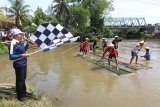 Plt Bupati Bengkulu Selatan Gusnan Mulyadi (kiri) mengangkat bendera start memulai lomba rakit menyusuri Sungai Air Manna, Batu Kuning, Bengkulu Selatan, Sabtu (9/3). Lomba yang diikuti oleh puluhan tim tersebut dalam rangka Festival Aiak Manna 2019 guna melestarikan olahraga tradisional sebagai kearifan lokal pendukung pada visit Bengkulu 2020 mendatang. (ANTARA FOTO)