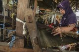 Perajin menganyam tikar mendong menggunakan alat tradisional di Kampung Pageur Gunung, Kota Tasikmalaya, Jawa Barat, Rabu (13/4/2019). Dalam sehari perajin mampu memproduksi 120 meter tikar mendong dan dijual dengan harga Rp 50 ribu hingga Rp 150 ribu per helai yang dipasarkan ke berbagai daerah di Pulau Jawa. ANTARA JABAR/Adeng Bustomi/agr
