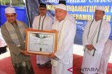 Pimpinan Pondok Pesantren Istiqamatuddin Babul Muaarif Serambi Aceh Kabupaten Aceh Barat, Abu H. Mahmuddin Usman sematkan gelar Guree & Santri Kehormatan kepada beberapa tokoh dari Manajamen PT Mifa Bersaudara pada Acara Saleum Teuka Guree & Santri, sekaligus penandatanganan prasasti serah terima Bangunan Balee Seumeubet & Drainase di Komplek Pondok Pesantren Istiqamatuddin Babul Muaarif, Aceh Barat, Aceh, Kamis (7/3/19). Penganugerahan ini diberikan atas kepedulian PT Mifa yang komit mendukung pendidikan keagamaan terhadap generasi muda islam khususnya di Aceh Barat melalui berbagai program beserta bantuan sarana dan prasarana pendidikan. (Antara Aceh/Syifa Yulinnas)