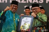 Gubernur Kalsel Sahbirin Noor yang di wakilkan oleh Sekdaprov Kalsel Abdul Harris Makkie (kanan) menerima BAZNAS Award Kategori Muzakki Prima yang diserahkan oleh Ketua BAZNAS H Gusti Rusdi Effendi (Kiri) dalam acara Malam Anugerah BAZNAS Kalsel 2019 di Banjarmasin, Kalimantan Selatan, Sabtu (16/3/2019).Badan Amil Zakat Nasional Provinsi Kalimantan Selatan memberikan penghargaan dengan kategori berbeda kesejumlah instansi di lingkup pemerintah Provinsi Kalsel. Foto Antaranews Kalsel/Bayu Pratama S.