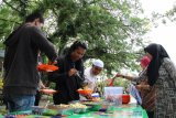 Sejumlah warga mengambil makanan yang dihidangkan secara gratis di Taman Burung, Singkawang, Kalimantan Barat, Jumat (15/3/2019). Santap siang gratis yang disajikan tiap usai sholat Jumat dan dibiayai dari hasil urunan sesama pegiat Komunitas Jumat Barokah itu dapat dinikmati oleh siapa pun yang datang ke taman kota tersebut. ANTARA FOTO/Jessica Helena Wuysang