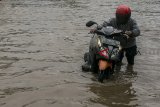 Warga mendorong kendaraan bermotor saat melintasi genangan banjir di Ruas Jalan Soekarno-Hatta, Gedebage, Bandung, Jawa Barat, Selasa (19/3/2018). Kawasan Gedebage, Kota Bandung tersebut kerap dilanda banjir dari aliran drainase yang kurang baik saat intensitas curah hujan yang tinggi sehingga mengakibatkan terganggunya arus lalu lintas di kawasan tersebut. ANTARA JABAR/Novrian Arbi/agr