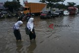 Pelajar melintasi genangan banjir di Ruas Jalan Soekarno-Hatta, Gedebage, Bandung, Jawa Barat, Selasa (19/3/2018). Kawasan Gedebage, Kota Bandung tersebut kerap dilanda banjir dari aliran drainase yang kurang baik saat intensitas curah hujan yang tinggi sehingga mengakibatkan terganggunya arus lalu lintas di kawasan tersebut. ANTARA JABAR/Novrian Arbi/agr