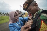 Seorang ibu melihat lencana anaknya yang merupakan seorang taruna seusai upacara penutupan pendidikan para dasar di Lanud Suparlan, Batujajar, Kabupaten Bandung Barat, Jawa Barat, Selasa (19/3/2019). Pendidikan para dasar yang diikuti sebanyak 258 Taruna Akmil tingkat IV tahun ajaran 2019 tersebut merupakan salah satu kualifikasi di lingkungan TNI Angkatan Darat, sebagai Pasukan Lintas Udara (Linud). ANTARA JABAR/Raisan Al Farisi/agr