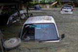 Sejumlah kendaraan terendam lumpur saat banjir bandang di Sentani, Kabupaten Jayapura, Papua, Minggu (17/3/2019). (Antara FOTO)