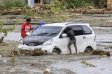 Kendaraan terendam lumpur saat banjir bandang di Sentani, Kabupaten Jayapura, Papua, Minggu (17/3/2019). (ANTARA FOTO)