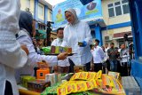 Kepala Badan Pengawas Obat dan Makanan, Penny K. Lukito (tengah) didampingi Deputi Bidang Penindakan , Hendrti Siswadi (kiri) dan kepala Balai Besar POM Aceh, Zulkifli (kanan), memeriksa sejumlah produk kosmetik, obat dan pangan ilegal saat pemusnahan di Banda Aceh, Rabu (20/3/2019). Badan POM memusnahkan sebanyak 58.125 pcs produk dalam negeri dan produk impor berupa komesmetik, obat, pangan dan obat tradisional senilai 1,262 miliar hasil penindakan dan pemeriksaan tahun 2018 di Aceh. (Antara Aceh/Ampelsa)