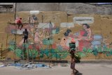 Mahasiswa melukis mural pada tembok Pasar Badung menjelang diresmikan di Denpasar, Bali, Kamis (21/3/2019). Pasar tradisional terbesar di Bali tersebut telah selesai pembangunannya kembali setelah musibah kebakaran dan rencananya akan diresmikan oleh Presiden Joko Widodo. ANTARA FOTO/Nyoman Hendra Wibowo/nym.
