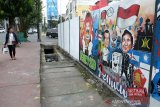 Warga melintas didepan mural 