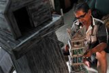 Perajin membuat miniatur Jam Gadang berbahan koran bekas di Kampung Narimbang, Lebak, Banten, Senin (25/3/2019). Miniatur tersebut dijual seharga Rp750 ribu dan dipasarkan secara online hingga ke sejumlah kota di Bali, Kalimantan, Sulawesi, Sumatra, dan Jawa. (ANTARA FOTO)