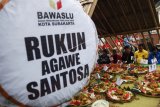 Warga Kampung Demokrasi bersama anggota Bawaslu Solo dan sejumlah kader partai politik melakukan doa bersama dan kenduri nasi kuning saat acara Kidung Pemilu Damai di Solo, Jawa Tengah, Minggu (24/3/2019). Kegiatan tersebut digelar untuk mengajak semua pihak menjaga pemilu 2019 berlangsung damai tanpa ada politik uang, hoaks, dan praktik menebar isu SARA. (ANTARA FOTO)