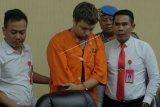 Polisi menggiring warga negara Rusia Zhestkov Andrei (tengah) yang menjadi tersangka kasus penyelundupan orangutan dalam konferensi pers di Gedung Wisti Sabha Angkasa Pura, Badung, Bali, Senin (25/3/2019). Warga negara Rusia tersebut ditangkap pada Jumat (22/3) di Bandara Ngurah Rai karena berupaya menyelundupkan orangutan untuk dijual di negaranya sehingga terancaman hukuman lima tahun penjara dengan denda mencapai Rp100 juta. (ANTARA FOTO)