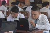 Sejumlah siswa mengerjakan soal Ujian Nasional Berbasis Komputer (UNBK) di Sekolah Menengah Kejuruan (SMK) Pariwisata Dalung, Badung, Bali, Senin (25/3/2019). UNBK SMK di Provinsi Bali diikuti sebanyak 32.102 dari 168 SMK yang dilaksanakan pada 25-28 Maret 2019. ANTARA FOTO/Fikri Yusuf/nym.