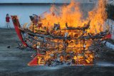 Umat Buddha mendokumentasikan acara ritual bakar replika kapal di Vihara Avalokitesvara, Pamekasan, Jawa Timur, Minggu (24/3/2019). Ritual bakar kapal tersebut dimaksudkan sebagai persembahan kepada dewa guna memperoleh kesuksesan dan keselamatan dalam menggapai masa depan. (ANTARA FOTO)