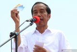 Capres nomor urut 01 Joko Widodo memperlihatkan kartu Pra Kerja saat berorasi dalam kampanye terbuka di Jalan Arteri Supadio, Kabupaten Kubu Raya, Kalimantan Barat, Rabu (27/3/2019). Selain memaparkan sejumlah pembangunan infrastruktur yang telah dikerjakan seperti perbatasan, pelabuhan dan bandara di wilayah Kalbar, Jokowi juga menjanjikan akan membangun jalan tol dan jembatan di provinsi tersebut. ANTARA FOTO/Jessica Helena Wuysang