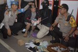 Petugas menunjukkan temuan barang bukti yang diduga terkait dengan transaksi narkoba milik narapidana Abdul Rahman Willy (kedua kiri) yang akan dipindahkan di Lapas Kerobokan, Bali, Rabu (27/3/2019). Sebanyak 10 orang narapidana kasus narkoba Lapas Kerobokan dipindahkan ke Lapas Nusakambangan untuk memberikan efek jera serta memutus mata rantai peredaran narkoba yang dilakukan dari dalam lapas. ANTARA FOTO/Fikri Yusuf/nym.