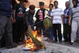 Sejumlah petani membakar gabah di halaman Gedung DPRD Jember, Jawa Timur, Kamis (28/3/2019). Dalam aksinya puluhan petani di Jember, membakar gabah dan membuang gabah di halaman gedung DPRD sebagai bentuk protes akibat anjloknya harga gabah kering sawah menjadi Rp.2.500 per Kg dan jauh di bawah Harga Pembelian Pemerintah (HPP) sebesar Rp .3.700 per Kg. (ANTARA FOTO)