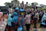 Personil Polri membagikan sembako kepada warga  saat berlangsung bakti sosial yang digelar Korps Binmas (Korbinmas) Polri di desa Lamlupu, kecamatan Peukan Bada, Aceh Besar, Aceh, Jumat (29/3/2019). Bhakti Sosial Polri yang turun ke desa desa di Aceh itu memberikan pengobatan gratis dan bantuan sembako kepada kaum duafa. (Antara Aceh/Ampelsa)