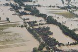 Kondisi banjir di wilayah Kabupaten Ngawi difoto dari udara menggunakan pesawat Helikopter NAS-332 Super Puma dari Skadron Udara 6 Lanud Atang Sanjaya Bogor yang dipiloti Mayor Pnb Nugroho Tri dan co-pilot Lettu Pnb Septian Sihombing yang sedang bertugas Bawah Kendali Operasi (BKO) di Lanud Iswahjudi, di Ngawi, Jawa Timur, Jumat (8/3/2019). Sebagian wilayah di Jawa Timur, antara lain Ponorogo, Madiun, Ngawi terendam banjir selama tiga hari sejak Rabu (6/3). Antara Jatim/Siswowidodo/zk.