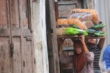 Seorang buruh perempuan membawa barang di atas kepalanya di kawasan Pasar Pabean, Surabaya, Jawa Timur, Jumat (8/3/2019). Untuk sekali angkut, para buruh perempuan tersebut mendapatkan upah mulai Rp500 hingga Rp5.000 tergantung berat barangnya. Antara Jatim/Moch Asim/zk.