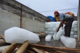 Pekerja menurunkan 'es balok' ke perahu nelayan di perairan Plawangan Puger, Jember, Jawa Timur, Jumat (8/3/2019). Nelayan yang menggunakan perahu jenis Pinisi tersebut membutuhkan sekitar 200 batang 'es balok' untuk menyimpan ikan hasil tangkapan dalam sepuluh hari melaut. Antara Jatim/Seno/zk.