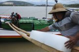 Pekerja menurunkan 'es balok' ke perahu nelayan di perairan Plawangan Puger, Jember, Jawa Timur, Jumat (8/3/2019). Nelayan yang menggunakan perahu jenis Pinisi tersebut membutuhkan sekitar 200 batang 'es balok' untuk menyimpan ikan hasil tangkapan dalam sepuluh hari melaut. Antara Jatim/Seno/zk.