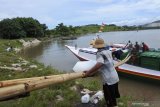 Pekerja menurunkan 'es balok' ke perahu nelayan di perairan Plawangan Puger, Jember, Jawa Timur, Jumat (8/3/2019). Nelayan yang menggunakan perahu jenis Pinisi tersebut membutuhkan sekitar 200 batang 'es balok' untuk menyimpan ikan hasil tangkapan dalam sepuluh hari melaut. Antara Jatim/Seno/zk.