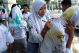 Sejumlah siswi SMK membubuhkan tanda tangan di baju seragam rekannya usai mengikuti Ujian Nasional Berbasis Komputer (UNBK) di Medan, Sumatera Utara, Kamis (28/3/2019). Aksi coret seragam dan membubuhkan tanda tangan tersebut dianggap para siswa sebagai bentuk kegembiraan usai mengikuti UNBK dan juga tradisi yang telah dilakukan senior mereka di tahun-tahun sebelumnya. (ANTARA FOTO)