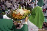 Pengurus muslimat NU membawakan tumpeng makanan untuk disantap bersama usai ritual istigotsah kubro di Lapangan GOR Lembupeteng, Tulungagung, Jawa Timur, Sabtu (23/3/2019). Istigotsah kubro itu digelar ribuan warga nahdliyin se-Tulungagung dalam rangkaian Harlah ke-96 NU serta untuk mendoakan terlaksananya Pemilu damai pada 17 April mendatang. Antara Jatim/Destyan Sujarwoko/zk.