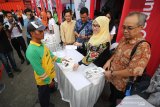 Direktur SDM dan Umum PT Pelayaran Nasional Indonesia (Persero) Ganefi (kedua kanan) menyerahkan paket sembako murah kepada warga disaksikan Komisaris PT PELNI Widodo Hario Mumpuni (kanan) dan Deputi Bidang Usaha Energi, Logistik, Kawasan dan Pariwisata Kementerian BUMN Edwin Hidayat Abdullah (ketiga kanan) di sela-sela acara Peringatan HUT ke-21 Kementerian BUMN oleh PT PELNI di Pelabuhan Tanjung Perak, Surabaya, Jawa Timur, Jumat (28/3/2019). Kegiatan yang diselenggarakan dalam rangka memeriahkan kebersamaan BUMN untuk HUT ke-21 Kementerian BUMN tersebut PT PELNI menyalurkan 5.000 paket sembako murah kepada warga dan CSR berupa 2.000 jaket keselamatan kepada pelaku pelayaran rakyat (pelra). Antara Jatim/Moch Asim/zk.