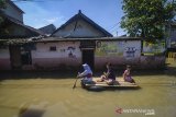 Warga melintasi banjir yang merendam Desa Bojongasih, Dayeuhkolot, Kabupaten Bandung, Jawa Barat, Jumat (29/3/2019). Banjir luapan Sungai Citarum setinggi satu hingga dua meter kembali merendam tiga RW di Desa Bojongasih sejak Rabu (27/3) akibat intensitas hujan yang lebat di Bandung Raya. ANTARA JABAR/Raisan Al Farisi/agr