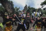 Seniman mementaskan Kesenian Bebegig berkolaborasi Wayang Landung pada pagelaran Karnaval Budaya Galuh di Jambansari, Kabupaten Ciamis, Jawa Barat, Sabtu (23/3/2019). Kesenian bebegig dan wayang landung merupakan kesenian tradisional asal Sukamantri dan Panjalu, Ciamis, dengan menampilkan atraksi menggunakan topeng menyeramkan, dengan rambut gimbal yang disusun dari bunga rotan atau bunga caruluk sedangkan wayang landung berwajah tokoh pewayangan berukuran raksasa, sebagian aksesorisnya menggunakan daun pisang kering. ANTARA JABAR/Adeng Bustomi/agr
