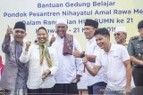 Menteri BUMN Rini Soemarno (kedua kiri) didampingi   Direktur Utama Pupuk Indonesia Aas Asikin Idat (kedua kanan) dan Wakil Bupati Karawang (ketiga kanan) Ahmad Zamaksyari berfoto bersama pengurus pesantren usai peletakan batu pertama pembangunan gedung belajar saat melakukan kunjungan kerja di Pondok Pesantren Nihayatul Amal, Rawa Merta, Karawang, Jawa Barat, Kamis (21/3/2019). Menurut Rini Soemarno masyarakat dapat bekerjasama dengan program BUMN secara teknis untuk membantu mensejahterakan masyarakat dalam bidang infrastruktur sehingga masyarakat terutama santri pondok pesantren bisa mendapatkan perbaikan sarana, prasarana, ekonomi dan pendidikan karena salah satu program BUMN yaitu 