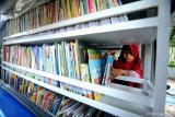 Seorang anak memilih buku koleksi  Perpustakaan Keliling saat Car Free Day (CFD) di Arek Lancor, Pamekasan, Jawa Timur, Minggu (31/3/2019). Selain mengisi libur akhir pekan bersama keluarga, arena CFD juga dimanfaatkan warga dan anak-anak bermain dan membaca buku yang disediakan perpustakaan keliling. Antara Jatim/Saiful Bahri/zk.