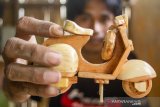 Perajin menunjukan miniatur vespa berbahan kayu jati belanda di Workshop MiniArt, Tanjungpura, Karawang, Jawa Barat, Rabu (20/3/2019). Himpunan Industri Mebel dan Kerajinan Indonesia (HIMKI) menargetkan ekspor mebel dan kerajinan tangan Indonesia meningkat 5 miliar dolar AS atau setara dengan Rp70 triliun di tahun 2019. ANTARA JABAR/M Ibnu Chazar/agr