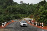 Sebuah mobil melintasi jalan paralel perbatasan di Kecamatan Siding, Kabupaten Bengkayang, Kalimantan Barat, Sabtu (30/3/2019). Jalan paralel perbatasan yang dibangun Kementerian Pekerjaan Umum dan Perumahan Rakyat (PUPR) bersama Direktorat Zeni TNI pada 2016 tersebut menjadi jalur perlintasan antara perbatasan Aruk, Kabupaten Sambas dengan Kecamatan Siding dan perbatasan Jagoi Babang, Kabupaten Bengkayang, Kalimantan Barat. ANTARA FOTO/Jessica Helena Wuysang