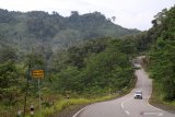 Sebuah mobil melintasi jalan paralel perbatasan di Kecamatan Siding, Kabupaten Bengkayang, Kalimantan Barat, Sabtu (30/3/2019). Jalan paralel perbatasan yang dibangun Kementerian Pekerjaan Umum dan Perumahan Rakyat (PUPR) bersama Direktorat Zeni TNI pada 2016 tersebut menjadi jalur perlintasan antara perbatasan Aruk, Kabupaten Sambas dengan Kecamatan Siding dan perbatasan Jagoi Babang, Kabupaten Bengkayang, Kalimantan Barat. ANTARA FOTO/Jessica Helena Wuysang