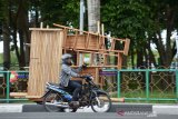 Pedagang menggunakan becak mesin memasarkan kursi kayu hasil produksi perajin saat melintas di salah satu ruas jalan kota Banda Aceh, Kamis (31/3). Kiat mendapatkan pasar dan meningkatkan omset penjualan, pedagang itu terpaksa berkeliling kota memasarkan kursi kayu. (Antara Aceh/Ampelsa)