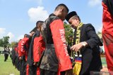 Seorang ketua perguruan silat mengikatkan sabuk pada prajurit TNI saat Pengukuhan Beladiri Militer Pencak Silat Nusantara di lapangan upacara Batalyon Para Raider 501/Bajra Yudha Madiun, Jawa Timur, Kamis (4/4/2019). Brigif Para Raider 18/Sarvatra Eva Yudha yang membawahi Batalyon Rara Raider 501/Bajra Yudha mengukuhkan bela diri pencak silat yang gerakannya berasal dari berbagai perguruan silat di nusantara untuk dijadikan beladiri militer. Antara Jatim/Siswowidodo/zk.