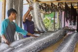 Pekerja menyelesaikan proses penyamakan kulit ular sanca kembang (Malayopython reticulatus) di Workshop Berkah, Kampung Bedeng, Desa Kutajaya, Karawang, Jawa Barat, Kamis (4/4/2019). Pekerja di workshop tersebut mampu menyamak 800 kulit ular per bulan dan dijual dengan harga Rp170 ribu - Rp200 ribu per meter tergantung jenis serta kualitas kulit ularnya untuk bahan baku kerajinan dompet, ikat pinggang, tas dan aksesoris lainnya. (ANTARA FOTO)