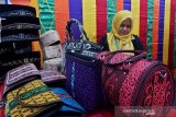 Penjaga stan Provinsi Aceh berada di dekat produk tas, dompet, dan peci hasil kerajinan UMKM, pada pameran Gelar Inovasi UMKM, Koperasi, dan Program Kemitraan Bina Lingkungan (PKBL), di Semarang, Jawa Tengah, Jumat (5/4/2019). Pameran yang menampilkan beragam produk industri kreatif UMKM dari berbagai provinsi dan kabupaten/kota serta mitra binaan perusahaan BUMN itu akan berlangsung hingga Senin (8/4). (ANTARA FOTO/R. Rekotomo/hp)