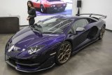 Model berpose di samping mobil Lamborghini Aventador SVJ yang dipamerkan pada ajang 